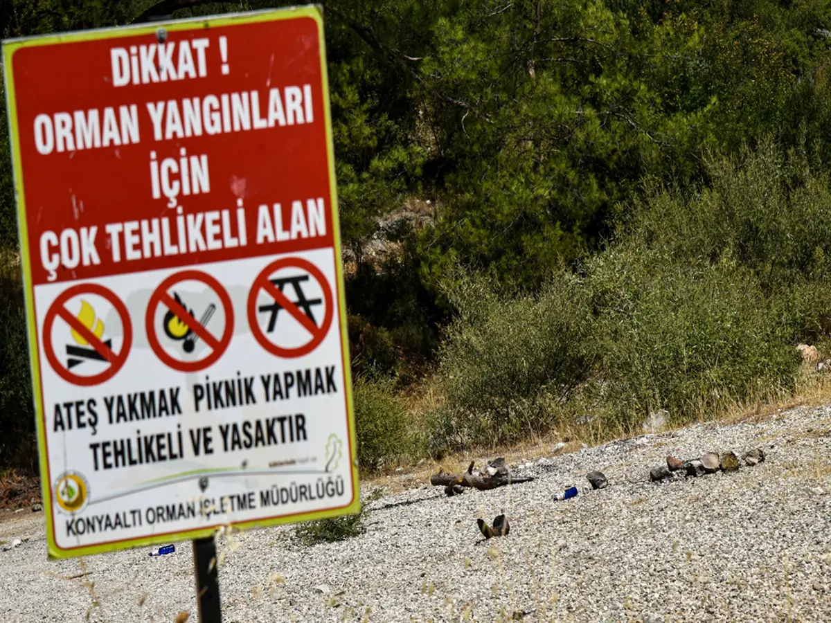 Antalya'da uyarı tabelasının dibinde mangal yaktılar. Cezalara da yasağa da aldırmadılar