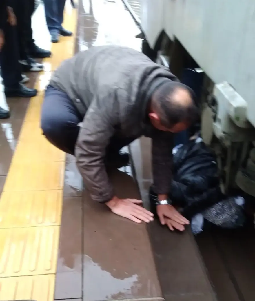 Trenle peron arasına sıkışan kadını makinistin dikkati kurtardı 