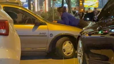 Kocasının gitmesini engellemek için aracın kaputuna yattı