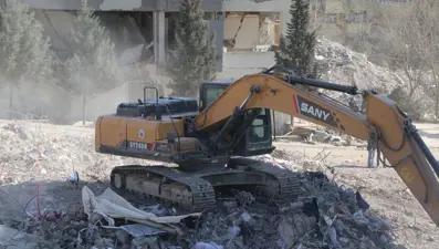 İş makinesi yıkılan binanın altında kalmaktan son anda kurtuldu