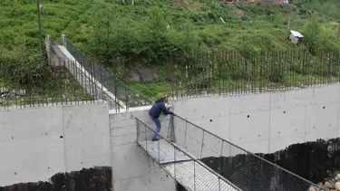 Ortasına duvar örülen asma köprü görenleri şaşırtıyor