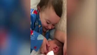 Kardeşini sevmeye doyamayan küçük çocuk