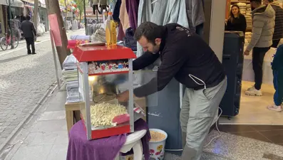 Dükkanın önü kalabalık görünsün diye bedava patlamış mısır dağıtıyor