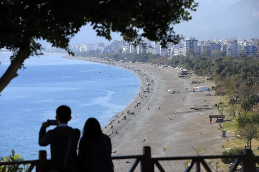 Aynı fotoğrafta hem yaz hem kış! Bir yanda kar yağışı, diğer yanda denize girenler 1