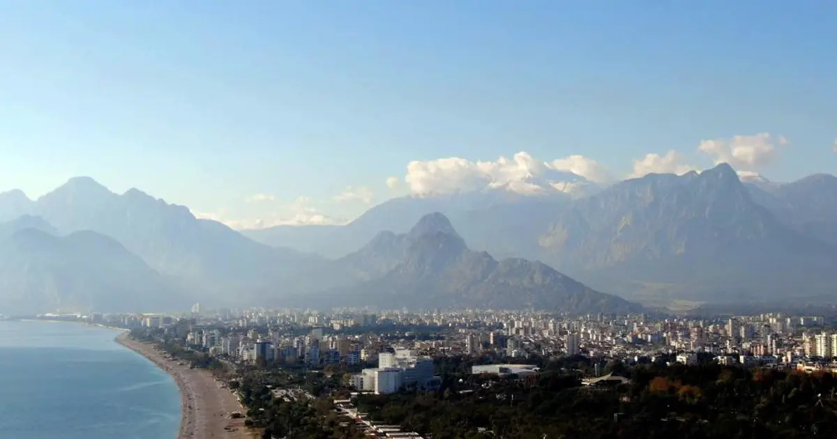 Aynı fotoğrafta hem yaz hem kış! Bir yanda kar yağışı, diğer yanda denize girenler