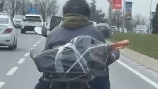 Mide bulandıran görüntü. Motorcu ayağının altında et taşıdı
