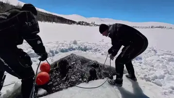 Buzla kaplı gölete nefes kesen dalış. Yüzeyi testereyle kestiler