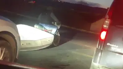 Trafikte 'pes' dedirten görüntü: Motosikletle yatak taşıdı