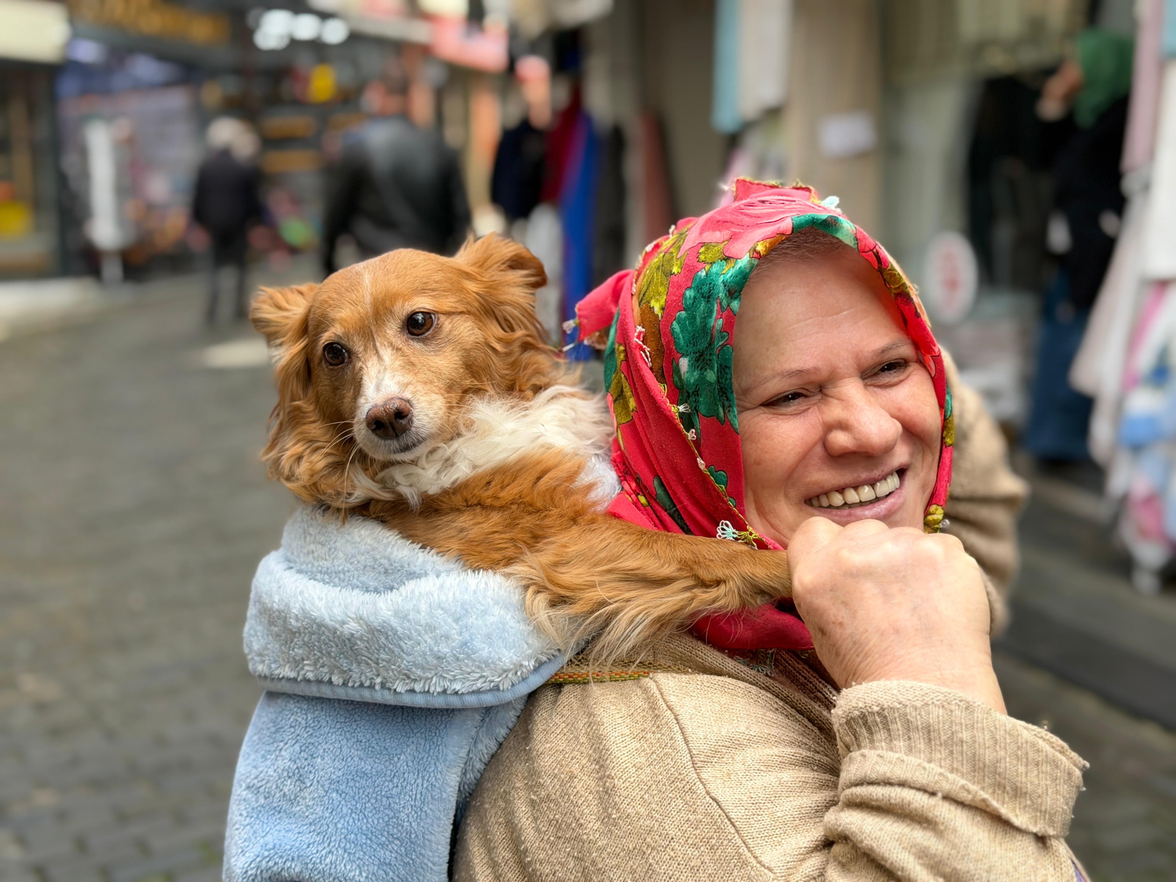 İnsanlardan korkan köpeğini sırtında taşıyor
