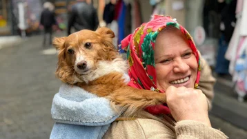 İnsanlardan korkan köpeğini sırtında taşıyor