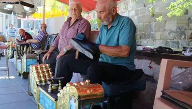 Üç kardeş, tarihi surların gölgesinde ayakkabı parlatıyor