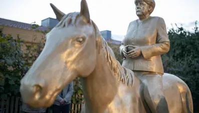Angela Merkel'i at üstünde tasvir eden dev heykel sergilenmeye başladı