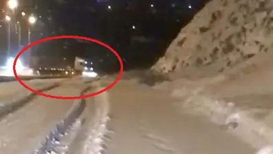 Karla kaplı yolda TIR'ın savrulma anı