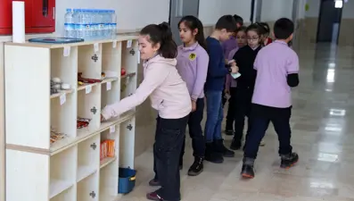 İlkokul öğrencileri kasiyer olmadan alışveriş yapıyor. Kasa açık değil, fazla verdi