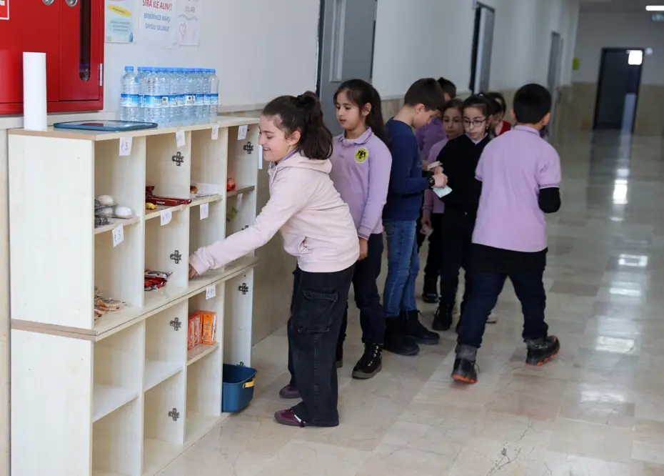 İlkokul öğrencileri kasiyer olmadan alışveriş yapıyor. Kasa açık değil, fazla verdi