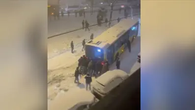 Esenler'de kar nedeniyle yokuşu çıkamayan İETT otobüsünü çevredekilerin itmesi kamerada
